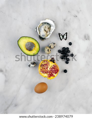Avocado,oyster,berry,quail egg,egg and pomegranate on marble background