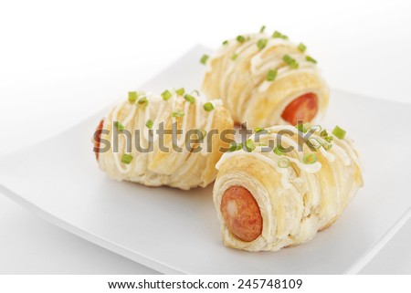 Tree delicious Sausage rolls puff on plate topping with mayonnaise