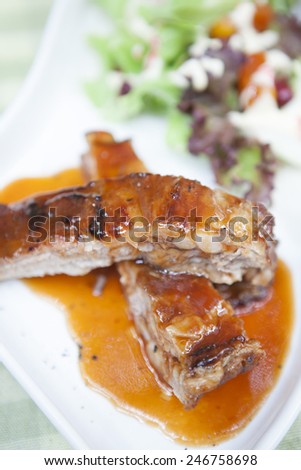 Pork rib stack with red sauce with salad,close up