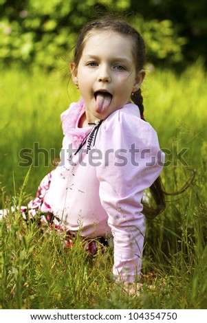 Little funny expressive girl with her tongue out, summer image