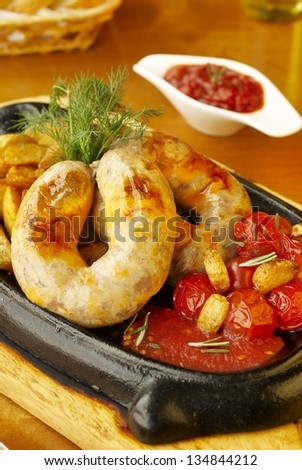 Beef sausage with roasted potatoes and baked tomatoes