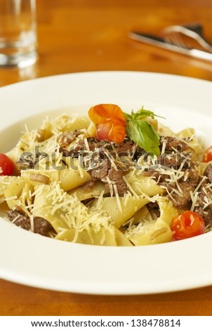 Pasta with meat, cherry tomatoes and grated cheese