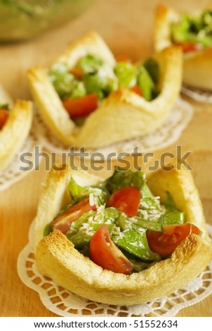 Salad with tomatoes and grated cheese in tartlets from bread slices