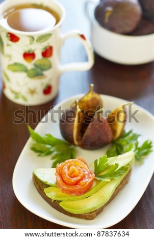 Sandwich with avocado and salmon, figs and tea