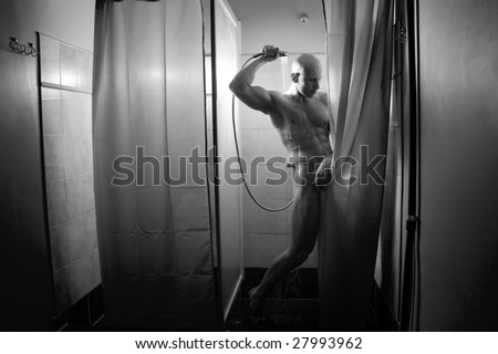 big muscular man is standing in the shower cabin