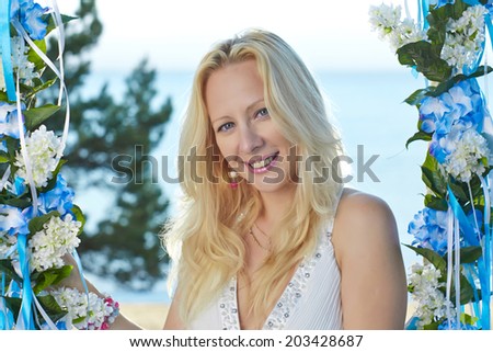 Young blond lady is relaxing and enjoying beautiful day near sea.