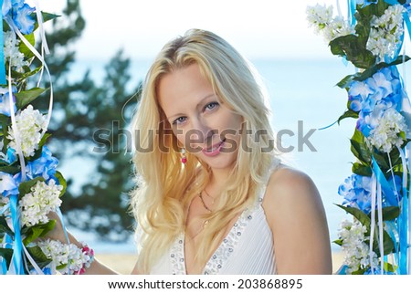 Young blond lady is relaxing and enjoying beautiful day near sea.