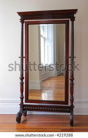 Big antique mirror in a wooden frame on legs