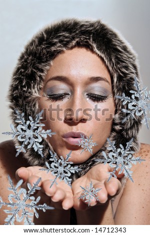 Beautiful ice queen blowing fake illustrated snow flakes. Woman has a fur scarf around her face