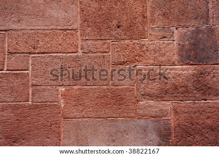 Red brick wall texture with different size bricks layered as a puzzle grunge backgound.
