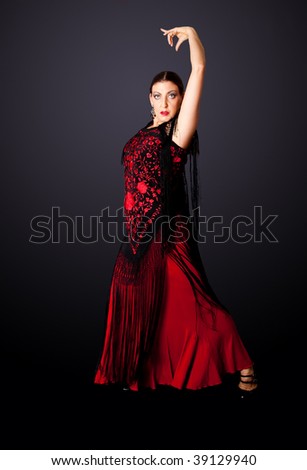 Beautiful female Spanish Flamenco dancer doing a typical line pose, wearing modern attire. Spanish woman dancing Paso Doble in red and balck dress clothes, isolated.