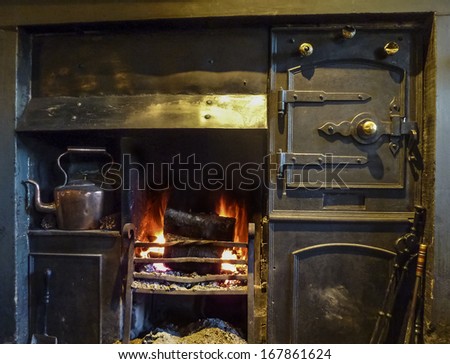 Black leaded range fireplace with fire burning and copper kettle