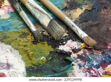 Paint brushes and palette of oil paints