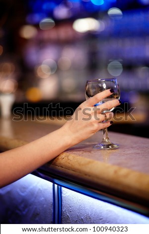 Girl\'s hand holding wine.Wine composition.Glass of yellow wine in the restaurant
