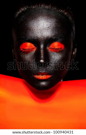 High fashion look.glamour fashion beautiful black American woman in black mask with orange bright makeup and orange lips with orange material