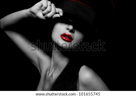 High fashion look.glamour portrait of beautiful sexy young female woman with red lips on black background with hat