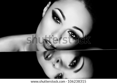 High fashion look.glamour fashion portrait of beautiful sexy brunette girl with bright makeup and her reflection in mirror table on dark