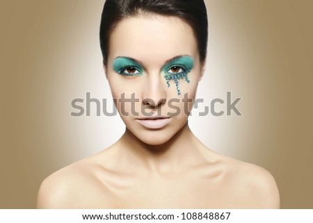 High fashion look.glamour closeup portrait of sexy beautiful brunette woman with black eyes and blue bright colorful makeup caucasian young female with perfect clean skin. Brown background