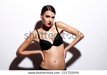 High fashion look.glamor portrait of beautiful sexy Caucasian young woman model with red lips,bright makeup, with perfect clean wet skin in black lingerie