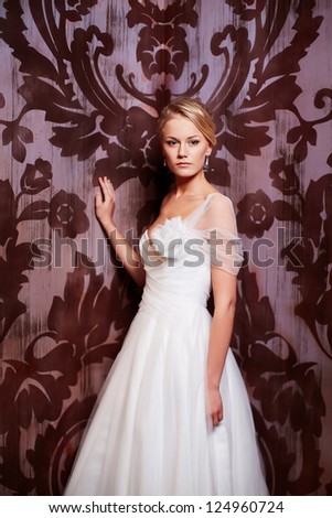 Happy beautiful sexy bride blond girl woman in white wedding dress with hairstyle and bright makeup in interior