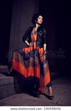 High fashion look.glamor portrait of beautiful sexy stylish brunette Caucasian young woman model in evening dress with bright makeup, with red lips with hairstyle in vogue style outdoors