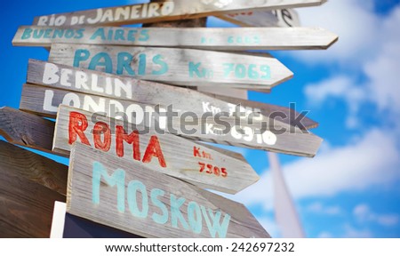 traffic road  sign including Moscow, Roma,London,Berlin,Paris, Rio de Janeiro on blue sky background in retro style