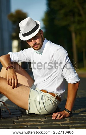Young stylish sexy handsome model man in casual cloth lifestyle in the street in hat