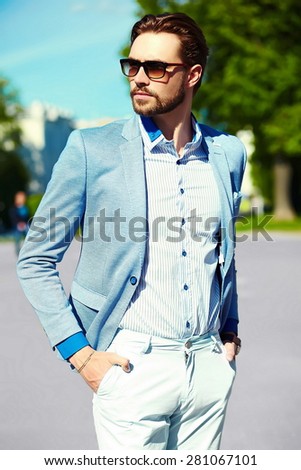 High fashion look.Young stylish confident happy handsome businessman model  in suit  lifestyle in the street in sunglasses