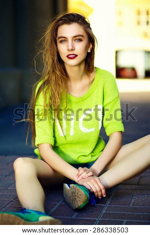 Funny  stylish sexy smiling beautiful young woman model in summer bright yellow   hipster cloth sitting in the street