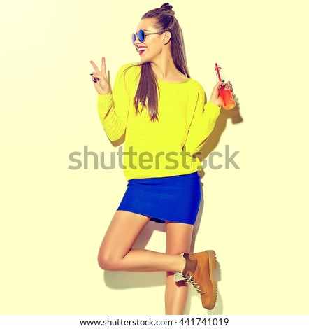 portrait of beautiful crazy smiling brunette woman girl in casual hipster summer colorful clothes with red lips isolated on white drinking soda from bottle with straw in sunglasses
