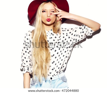 Stylish sexy beautiful young blond woman model in summer jeans hipster clothes in hat giving a kiss