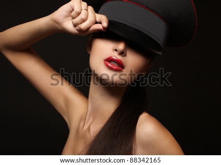 Portrait of beautiful young woman with red lips on black background