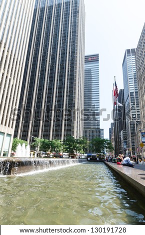 NEW YORK CITY - JULY 12: Undefined people rest near a fountain Avenue of the  Americas on July 12, 2012. Sixth Avenue is a major thoroughfare in New York City\'s borough of Manhattan.
