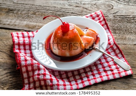 Panna cotta with berry sauce and maraschino cherry