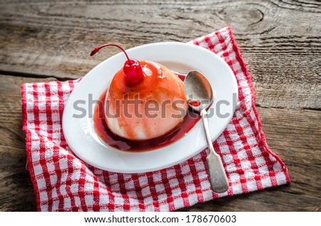 Panna cotta with berry sauce and maraschino cherry