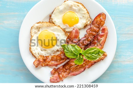 Fried eggs with bacon on the wooden table