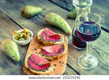 Slices of italian salami with pears and wine