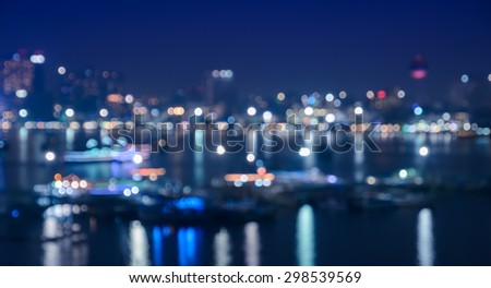 Blurred city skyline lights illuminated at night with reflection on river