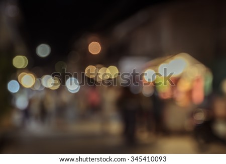 Blurred image of tourists walking at night market