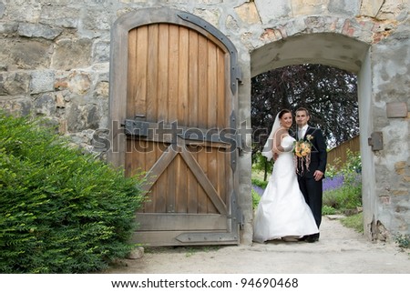 Wedding couple smile, castle wall open gate