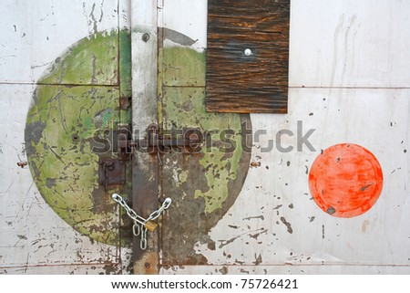 Colored circles painted on locked door of old industrial warehouse