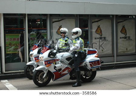 two motorcycle police at an intersection in central, hong kong