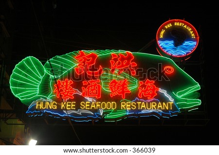 neon bright lights of a Chinese seafood restaurant in hong kong - the mouth of the fish on the sign flashes open and closed