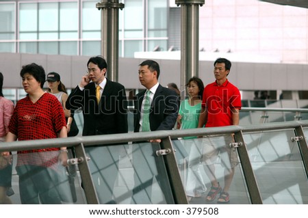 A group of pedestrians, including business people, on a pedestrian flyover in exchange square, central district, hong kong