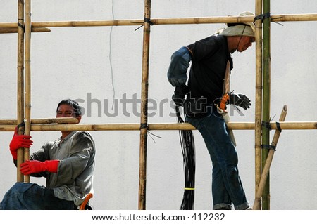 construction workers erecting bamboo scaffolding at a building construction site in Hong Kong.