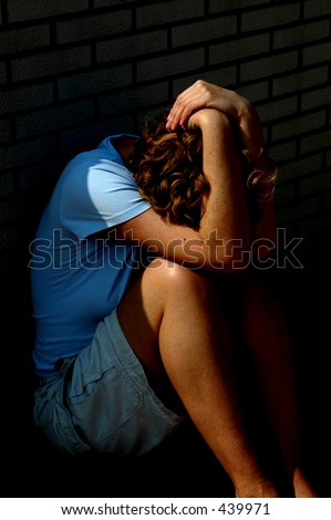 Image of a woman in a physical position showing sadness and despair with the photo intentionally darkened to set the mood