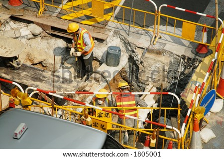 Team of road workers at site along the street in Central district, Hong Kong, China SAR