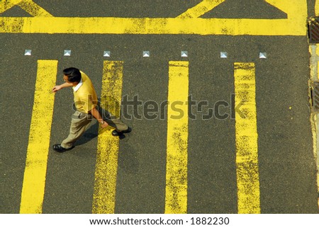 Man in yellow crossing intersection with yellow stripes