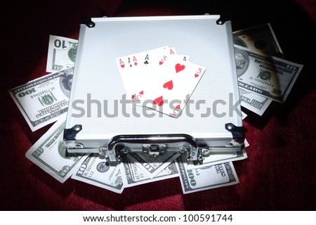 aluminum case with money and playing cards under the spotlight