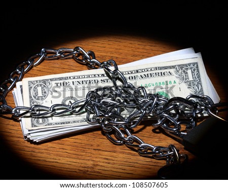 Chain and dollar bills in spot light
